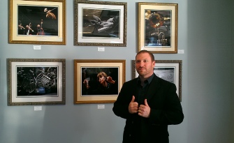 man standing in front of pictures in a museum